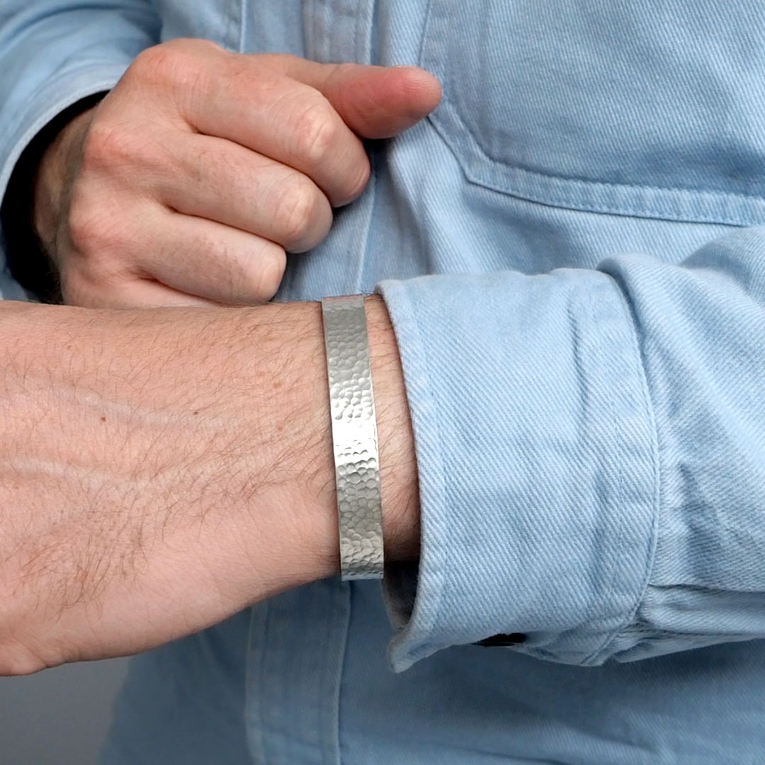 Photo d'un poignet d'homme avec le bracelet fabriquer durant l'atelier créer son bracelet.